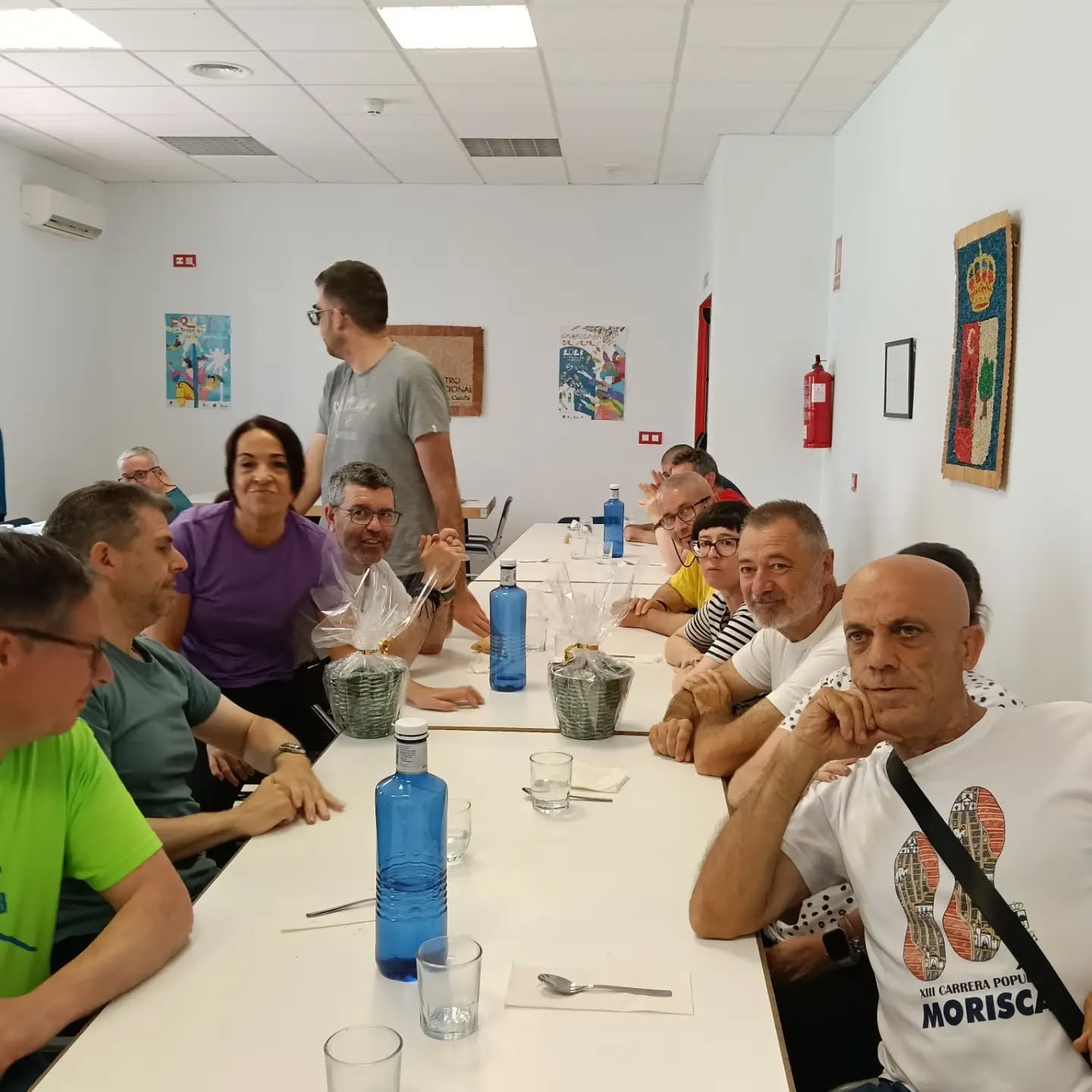Socios y participantes comparten una comida en un ambiente comunitario y acogedor dentro del centro ocupacional.